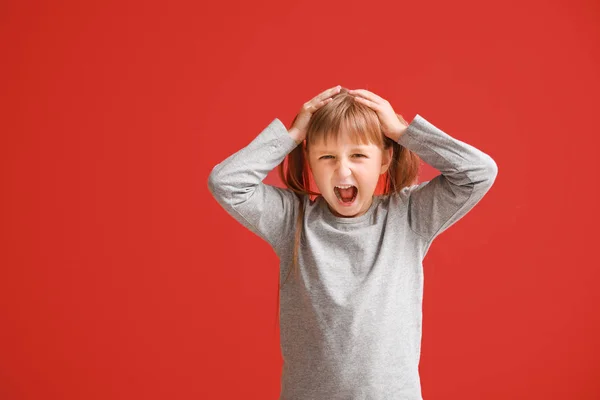 Portrait of angry little girl on color background — Stock Photo, Image