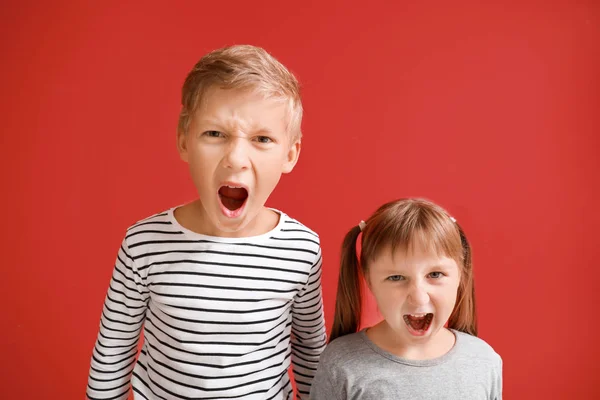 Portrait of angry little children on color background — Stock Photo, Image