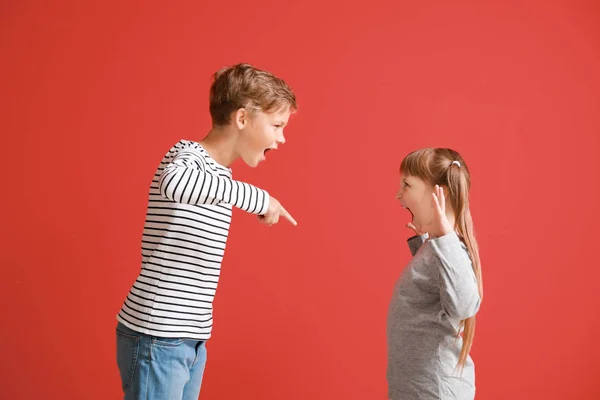 Portrait of quarreling little children on color background — Stock Photo, Image