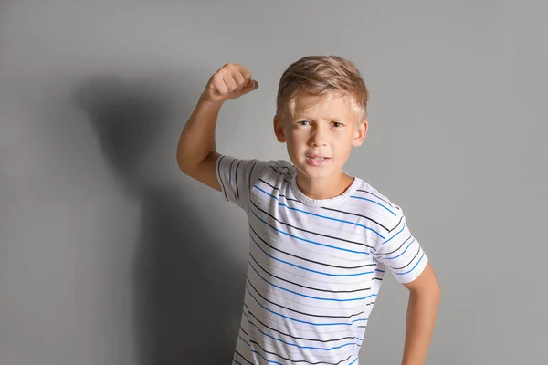Porträt eines wütenden kleinen Jungen auf grauem Hintergrund — Stockfoto