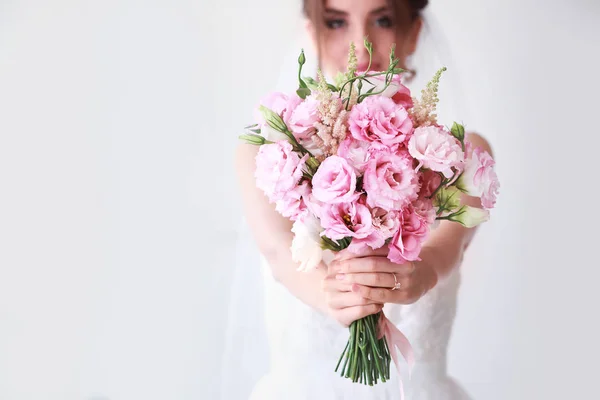 Krásná mladá nevěsta s kyticí před svatební obřadností doma — Stock fotografie