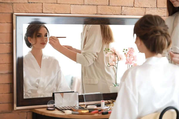 Professional makeup artist working with young bride at home — Stock Photo, Image