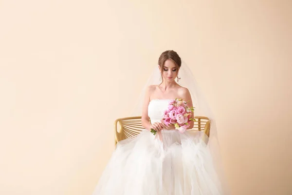 Portrait of beautiful young bride with wedding bouquet on light background — Stock Photo, Image