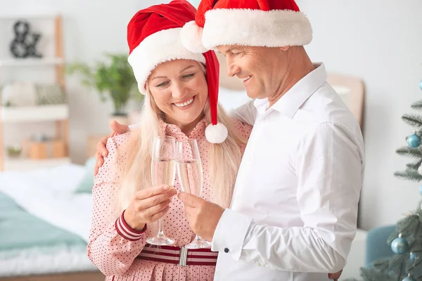 Äldre par med glas champagne firar julen hemma — Stockfoto