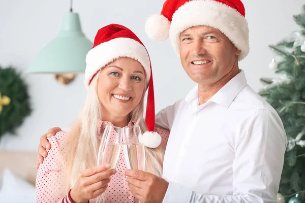 Äldre par med glas champagne firar julen hemma — Stockfoto