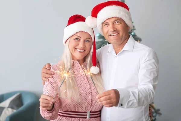 Boldog érett pár karácsonyi csillagszórók otthon — Stock Fotó