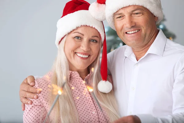 Happy mature couple with Christmas sparklers at home — Stock Photo, Image