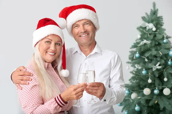 Casal maduro com copos de champanhe celebrando o Natal em casa — Fotografia de Stock