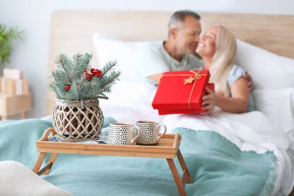 Cups of cacao with decor on tray in bedroom of mature couple — Stock Photo, Image