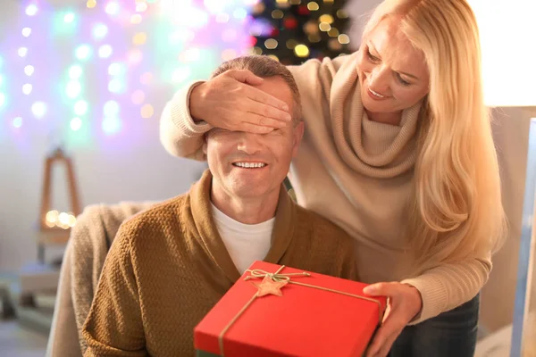 Mogen fru ger sin man julklapp hemma — Stockfoto