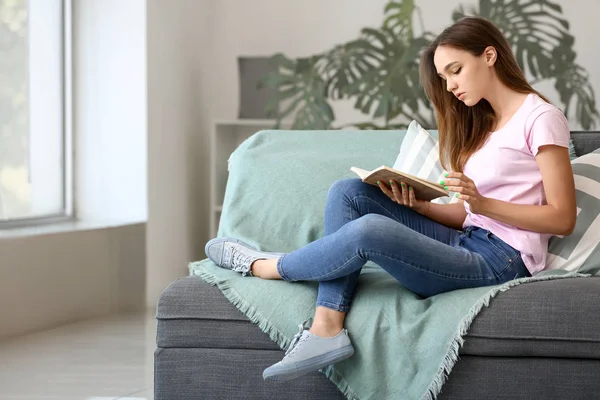Genç kız evde kitap okurken — Stok fotoğraf
