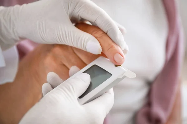 Ο γιατρός ελέγχει το επίπεδο του σακχάρου στο αίμα διαβητική γυναίκα στο σπίτι, κοντινό πλάνο — Φωτογραφία Αρχείου