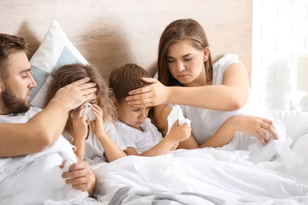 Семья больная гриппом в постели дома — стоковое фото