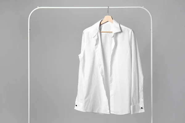 Rack with stylish shirt on grey background