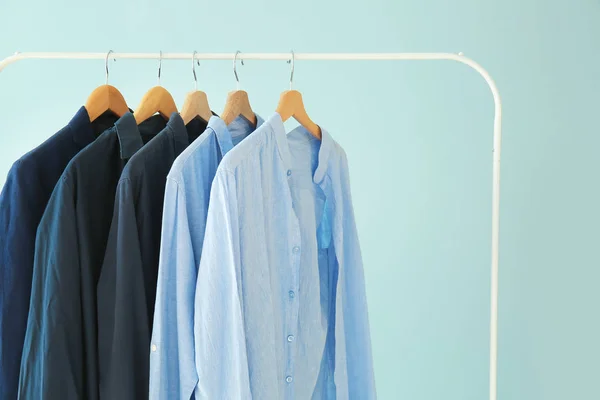 Bastidor con ropa elegante sobre fondo de color — Foto de Stock