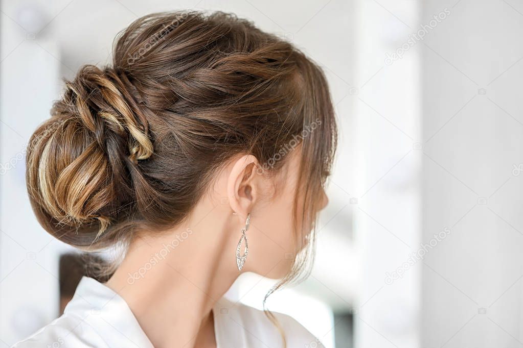 Beautiful young bride with elegant hairstyle before wedding ceremony at home