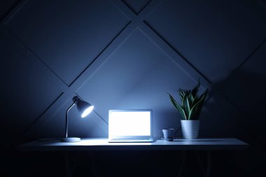Akşam dizüstü bilgisayar ile modern işyeri