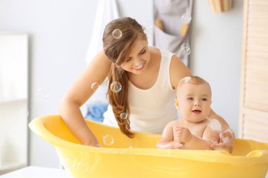 Anne evde onu sevimli küçük bebek banyo