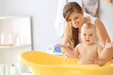 Anne evde onu sevimli küçük bebek banyo