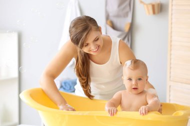 Anne evde onu sevimli küçük bebek banyo