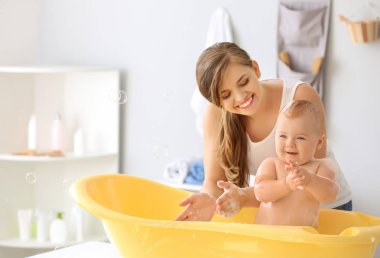 Anne evde onu sevimli küçük bebek banyo