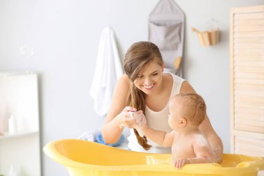 Anne evde onu sevimli küçük bebek banyo