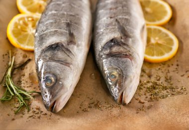 Parşömen üzerinde baharat ve limon ile taze levrek