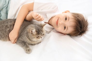 Yatak odasında sevimli kedi ile küçük çocuk