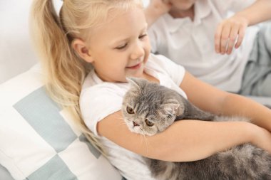 Yatak odasında sevimli kedi ile küçük çocuklar