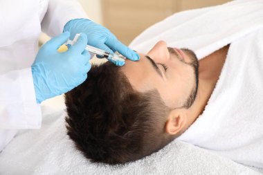 Güzellik salonunda dolgu enjeksiyonu alan yakışıklı adam