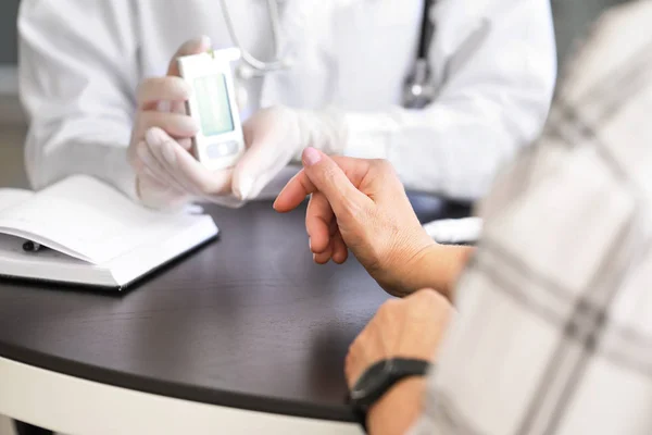Ο γιατρός ελέγχει το επίπεδο του σακχάρου στο αίμα του διαβητικού ασθενούς στην κλινική — Φωτογραφία Αρχείου