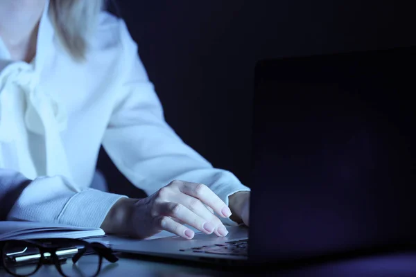 Kvinna som arbetar på laptop vid bordet i kväll — Stockfoto