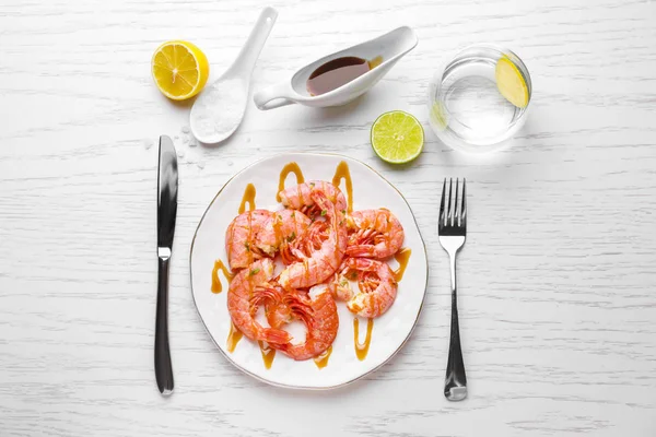 Placa con sabrosos camarones sobre mesa blanca — Foto de Stock