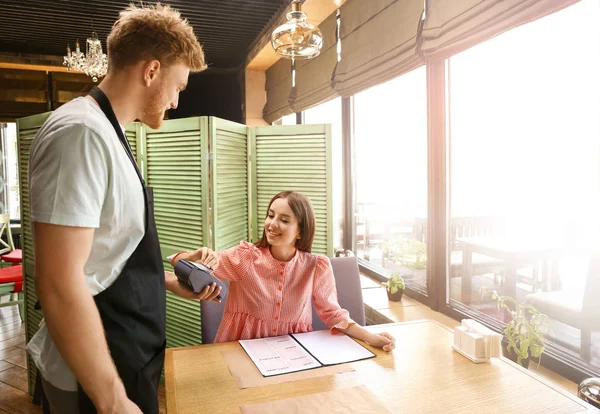 Woman paying bill in restaurant through terminal — Stock Photo, Image