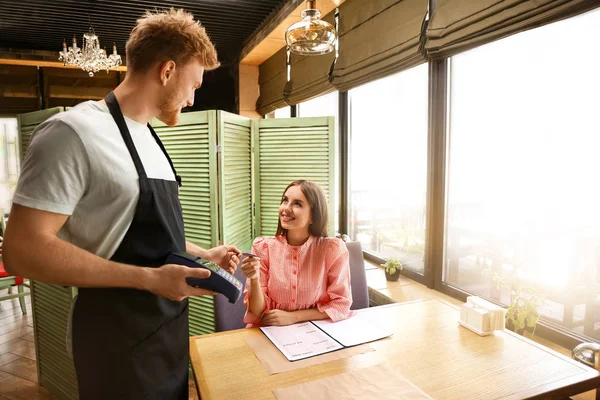 Woman paying bill in restaurant through terminal — Stock Photo, Image