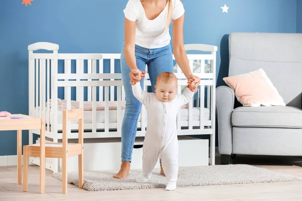 Mother teaching her little baby to walk at home — Stock Photo, Image