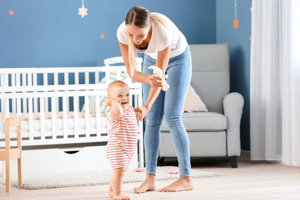 Mother teaching her little baby to walk at home — Stock Photo, Image