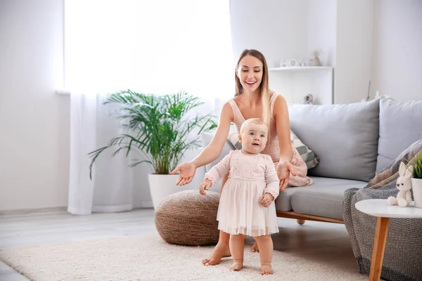 Mother teaching her little baby to walk at home — Stock Photo, Image