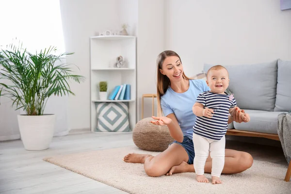 Madre enseñando a su pequeño bebé a caminar en casa — Foto de Stock