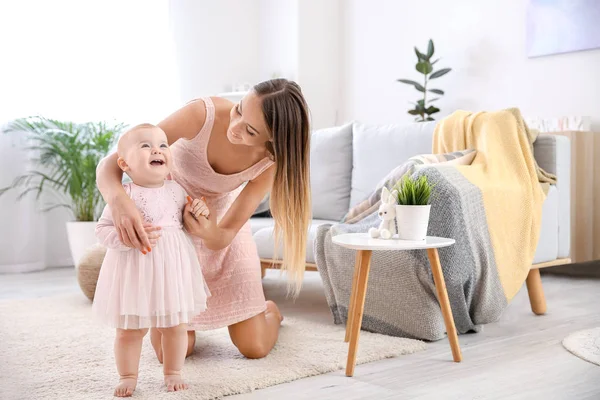 Mutter lehrt ihr kleines Baby zu Hause laufen — Stockfoto