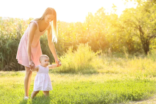 Mamma lär henne lilla barnet att gå utomhus — Stockfoto