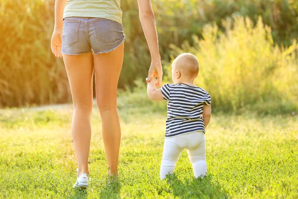 Mãe ensinando seu bebê a andar ao ar livre — Fotografia de Stock
