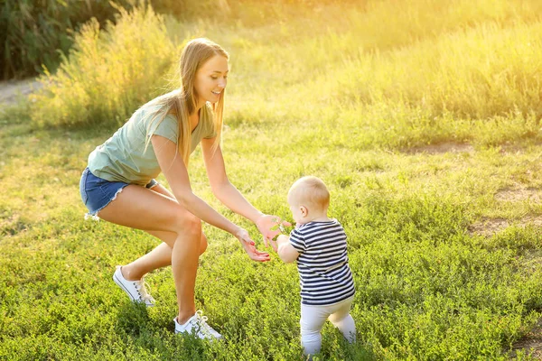 Mãe ensinando seu bebê a andar ao ar livre — Fotografia de Stock