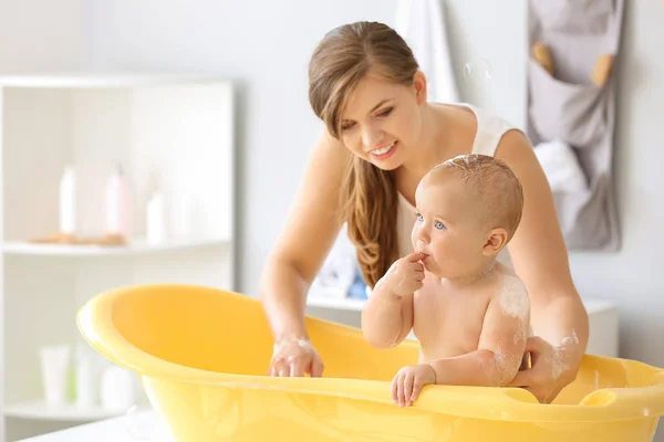 Madre bagnando il suo piccolo bambino carino a casa — Foto Stock