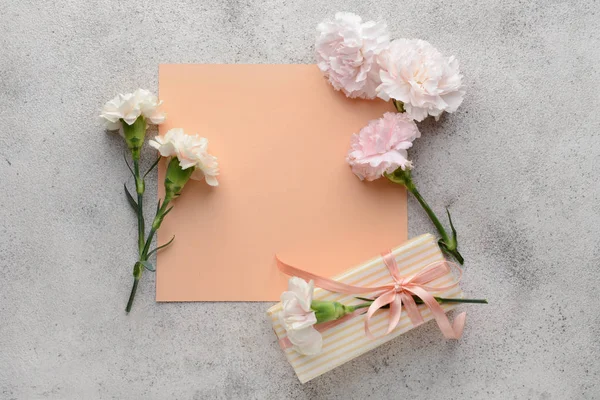 회색 배경에 아름다운 카네이션 꽃과 선물 상자와 인사말 카드 — 스톡 사진