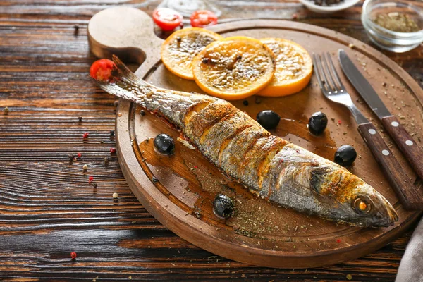 Plateau avec de savoureux poissons de mer cuits sur une table en bois — Photo