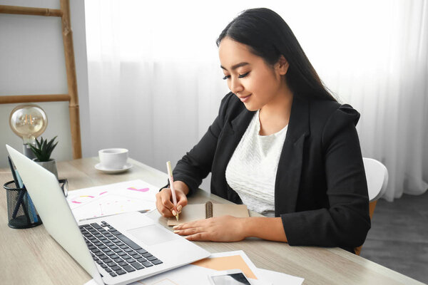 Beautiful Asian businesswoman working in office