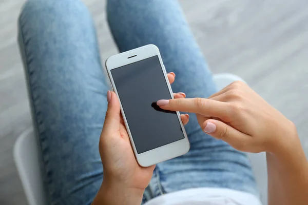 Young woman using modern mobile phone at home, closeup — Stock Photo, Image