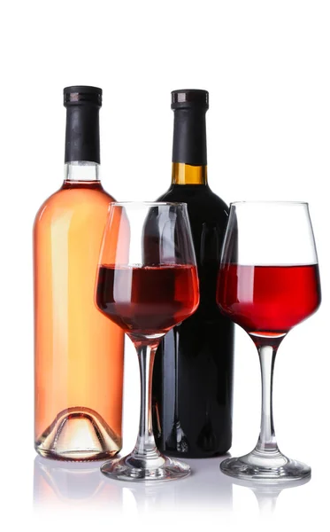 Copos e garrafas de diferentes vinhos sobre fundo branco — Fotografia de Stock
