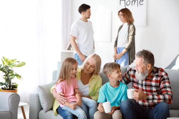 Großeltern mit kleinen Kindern ruhen sich zu Hause aus — Stockfoto